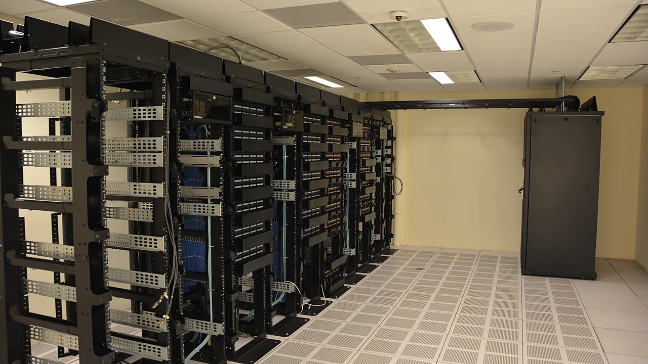 Rows of open server racks with network cabling in a data center room