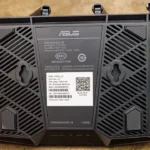 Underside of an ASUS TUF Wi-Fi router showing its network label with SSID and PIN
