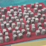 Rows of bronze Chinese movable-type printing blocks on red felt