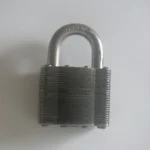 A laminated steel padlock, closed, on a white surface