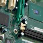 Close-up of a computer motherboard showing an Intel chip, PCI slots, and capacitors