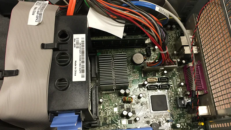 A green computer motherboard with expansion slots and ports