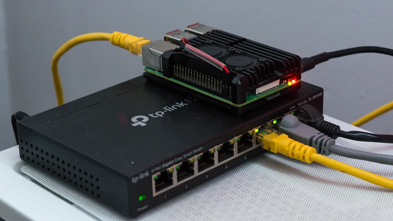 Raspberry Pi with a heatsink case sitting on top of a TP-Link network switch
