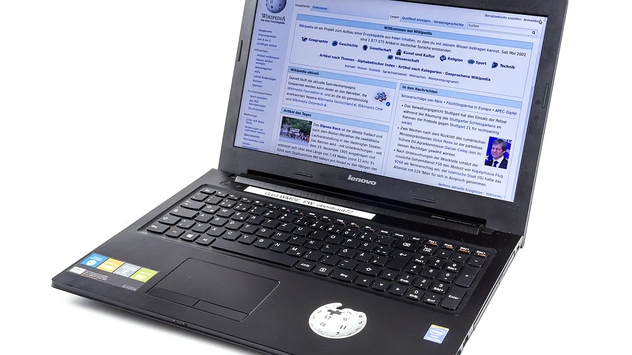 An open Lenovo G500s laptop showing a brightly lit web page on its screen