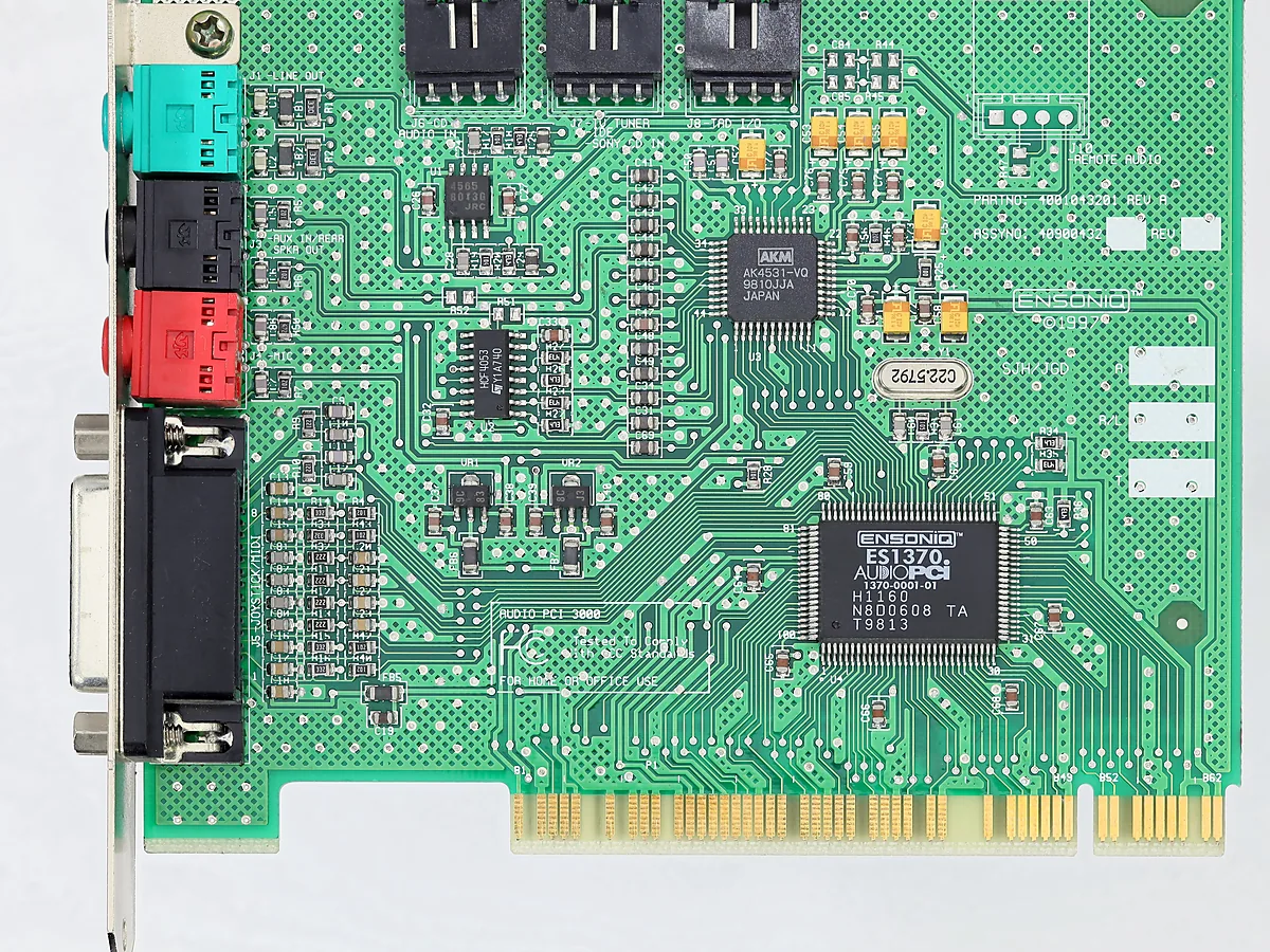 A green PCI sound card showing colour-coded audio sockets in turquoise, black and red beside a joystick port.