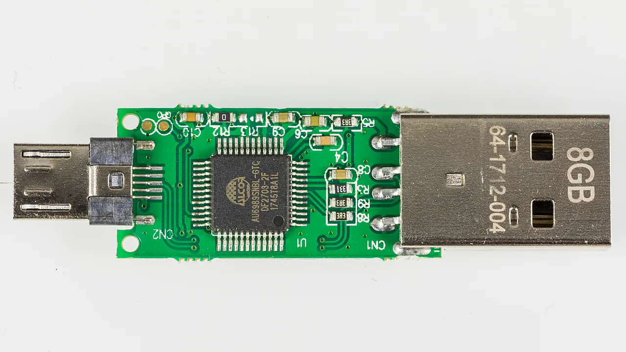 An 8 GB USB flash drive with its casing removed, exposing the controller chip and USB-A plug